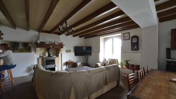 A cozy living room with a sofa, wooden dining table, and a television. - Etxe Arrosa (Saint-Martin-d'Arrossa)