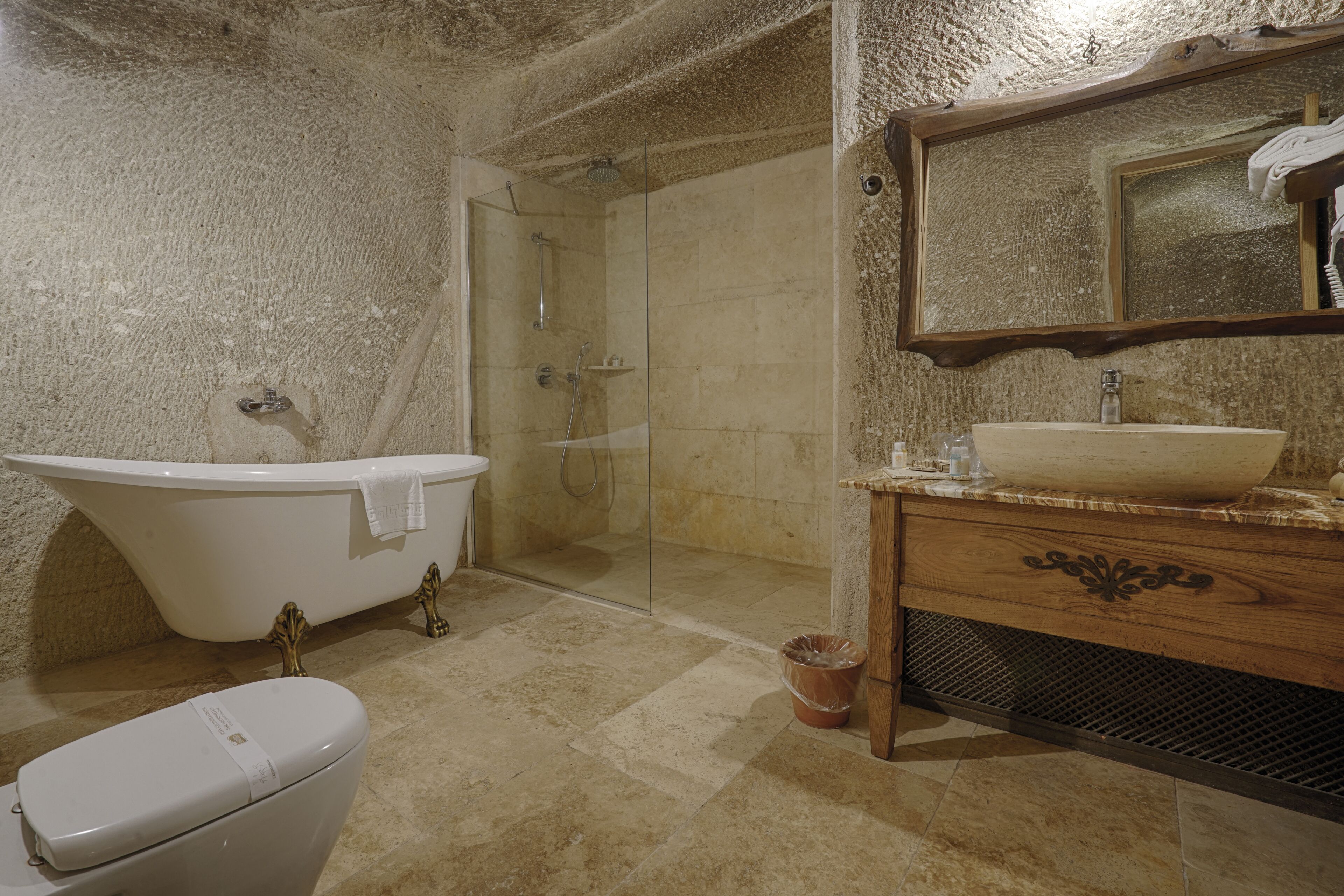 Un baño con una bañera independiente, un lavabo con recipiente y un espejo sobre el tocador.