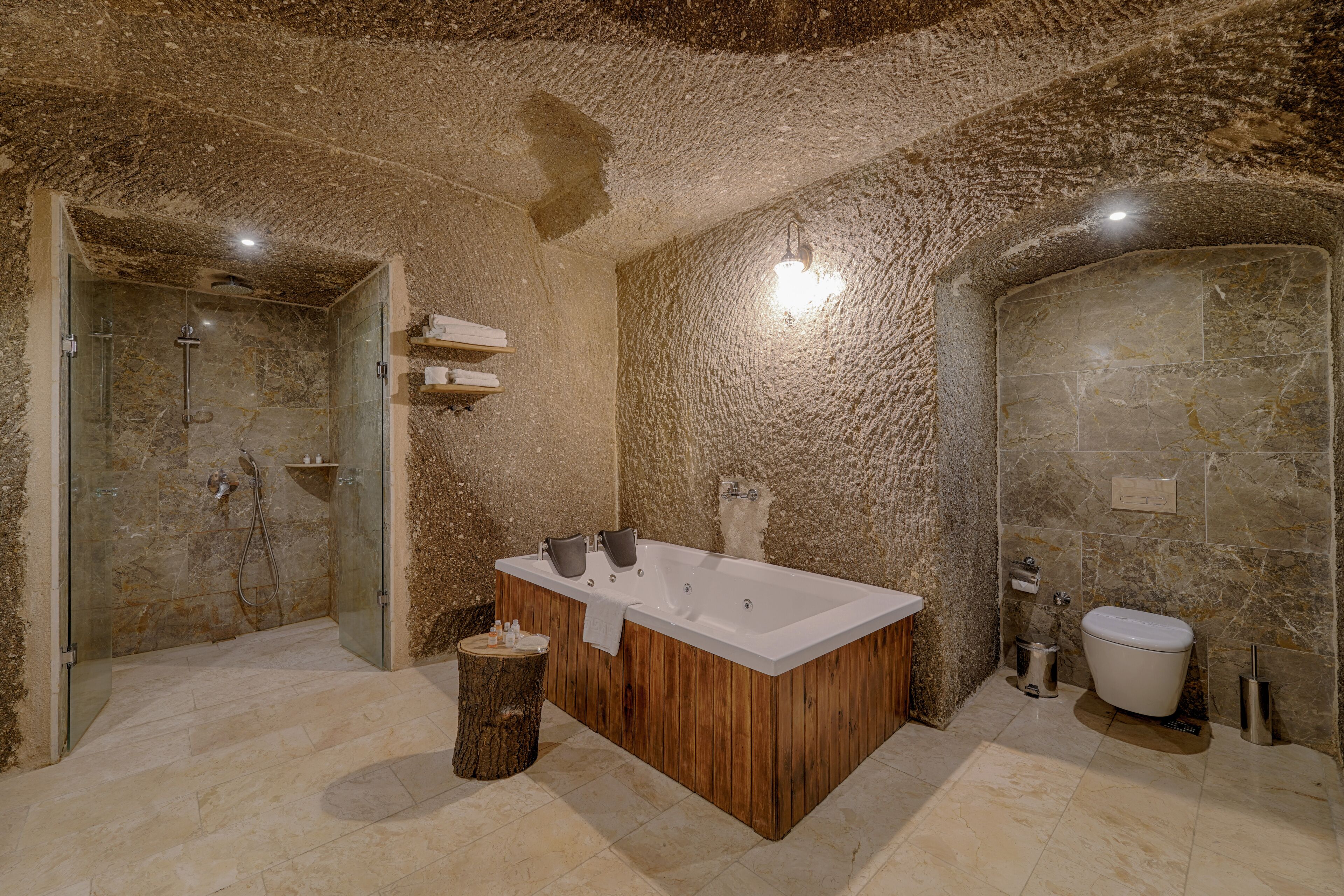 Un baño moderno con una bañera independiente, ducha con cerramiento de vidrio y suelo de mármol.