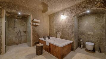 Un baño moderno con una bañera independiente, ducha con cerramiento de vidrio y suelo de mármol.