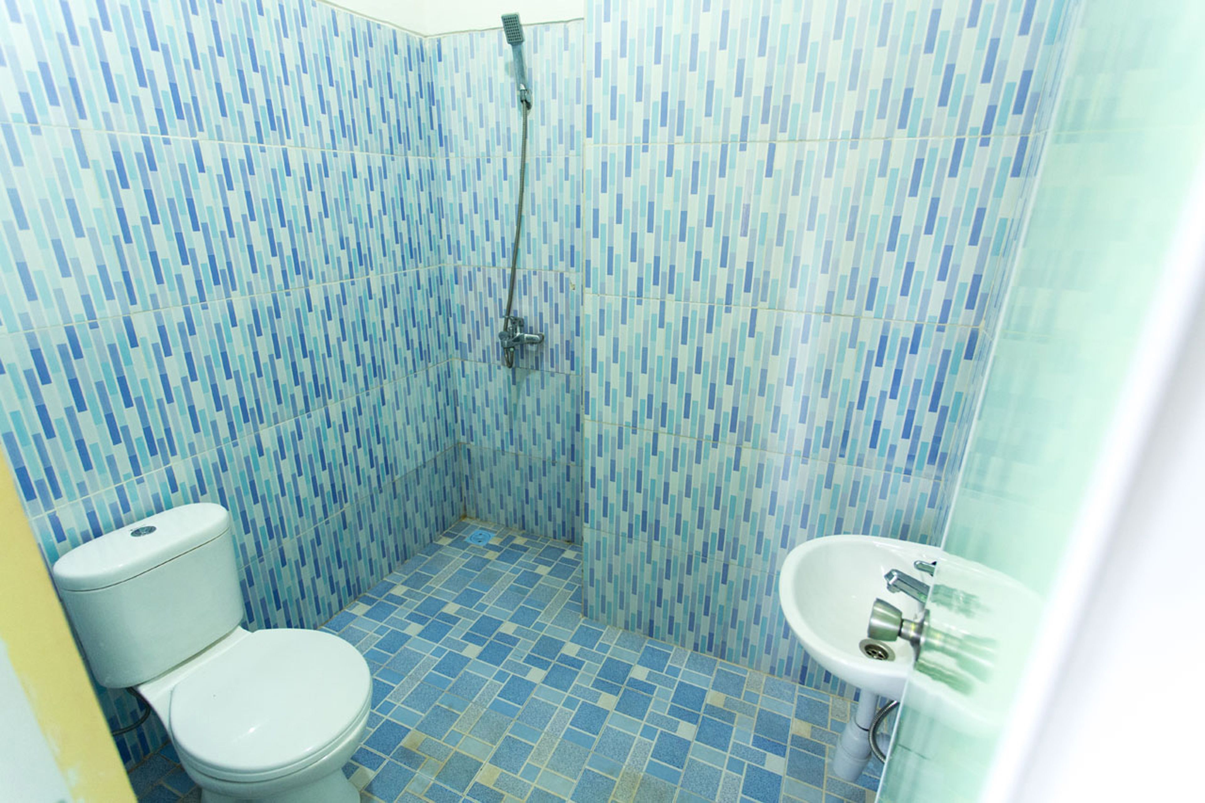A bathroom with a shower, toilet, and sink.