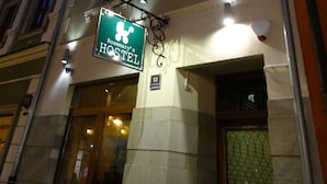 A hostel with a green sign, classical architecture, and a number 13 on the building. - Rosemary's B&B (Poznan)