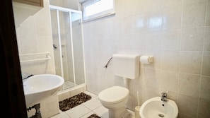 Un baño con ducha, inodoro, lavabo y bidé.
