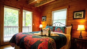 Quarto de cabana de madeira com uma cama, duas luminárias de cabeceira e uma janela com persianas.