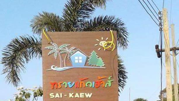 A sign for Sai-Kaeow House with palm trees and a house illustration. - Sai Kaew House (Mai Khao)