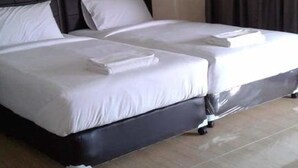 A double bed with a black headboard and white bedding in a hotel room. - Sai Kaew House (Mai Khao)