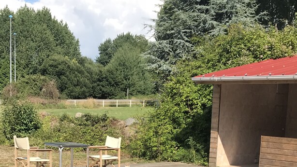 An outdoor patio with wooden furniture and a pool. - Le Salin (Brehal)