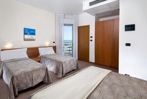 Habitación cuádruple familiar, vistas al mar | Caja fuerte, escritorio, wifi gratis y ropa de cama
