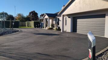 A modern building with a garage, a driveway, and a well-maintained lawn.