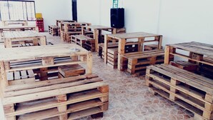 Una stanza con diversi tavoli e panche in legno, disposti in modo informale.