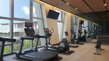 A gym with treadmills, elliptical machines, and weight benches.