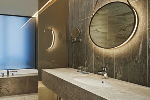 Een moderne badkamer met een grote spiegel, een badkuip en een wastafel.
