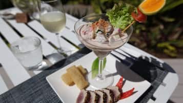 A seafood dish with a glass of white wine on a white table.
