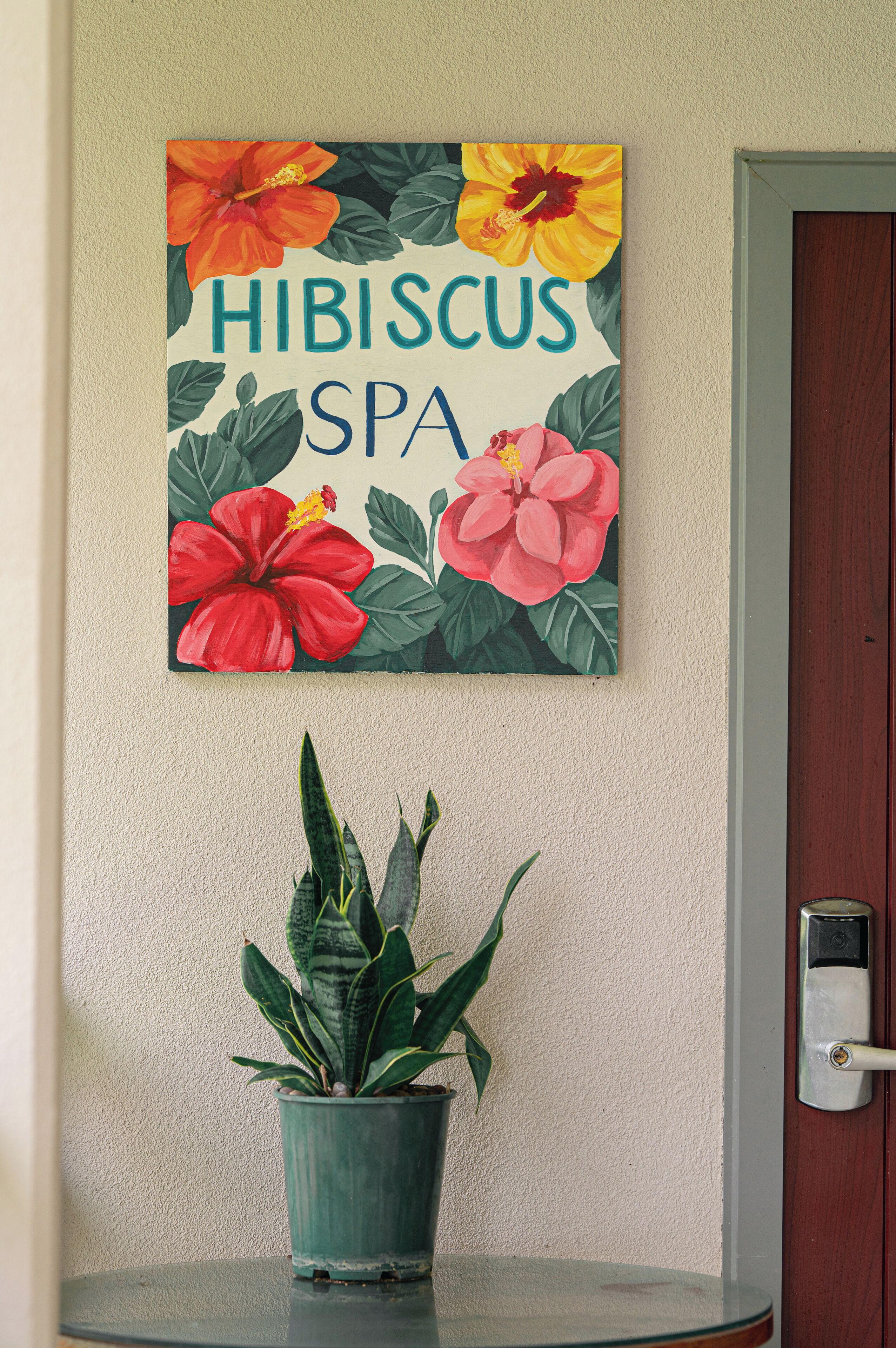 A wall-mounted sign with hibiscus flowers and the text "HIBISCUS SPA".