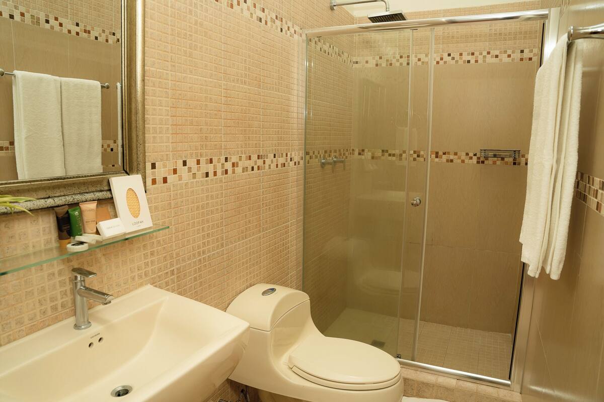 deluxe double room, 2 queen beds | bathroom | shower, rainfall showerhead, free toiletries, hair dryer