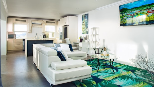 Un salon moderne avec un canapé, une table basse et un tableau accroché au mur.
