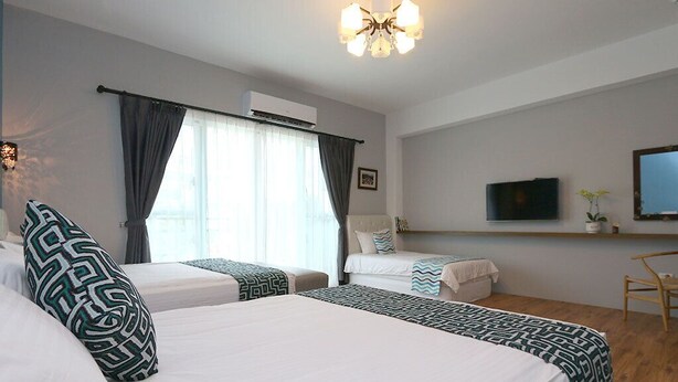 Une chambre d’hôtel avec deux lits, une télévision, un bureau et une chaise.