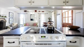 Una cocina con armarios blancos, estufa y una isla grande.