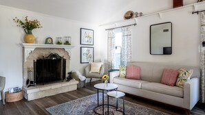 Una sala de estar con chimenea, un sofá, una mesa de centro y un sillón.