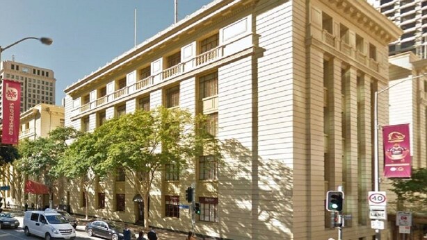 A multi-story building with a classical architectural style, featuring a central entrance with a balcony. - S&P Apartments - Central Station (Brisbane)