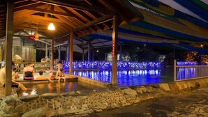 An outdoor heated pool area with stone walls and a covered seating area. - CDR Hotspring Resort (Kaohsiung)