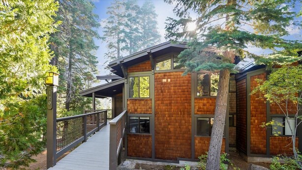 A modern wooden cabin with a wooden deck and a small bridge leading to the entrance. - Fantastic Forest Setting Rocky Ridge #120 (Tahoe City)