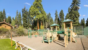 A playground with a slide, climbing structures, and a bench. - Fantastic Forest Setting Rocky Ridge #120 (Tahoe City)