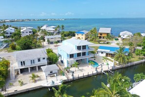 A coastal property with multiple buildings, a dock, and a clear view of the ocean. - Beautiful, 2100 sq ft 3/2 w/ocean views & easy ocean & gulf access. (Cudjoe Key)