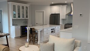Una cucina moderna con mobili bianchi, un frigorifero in acciaio inossidabile e un forno integrato.