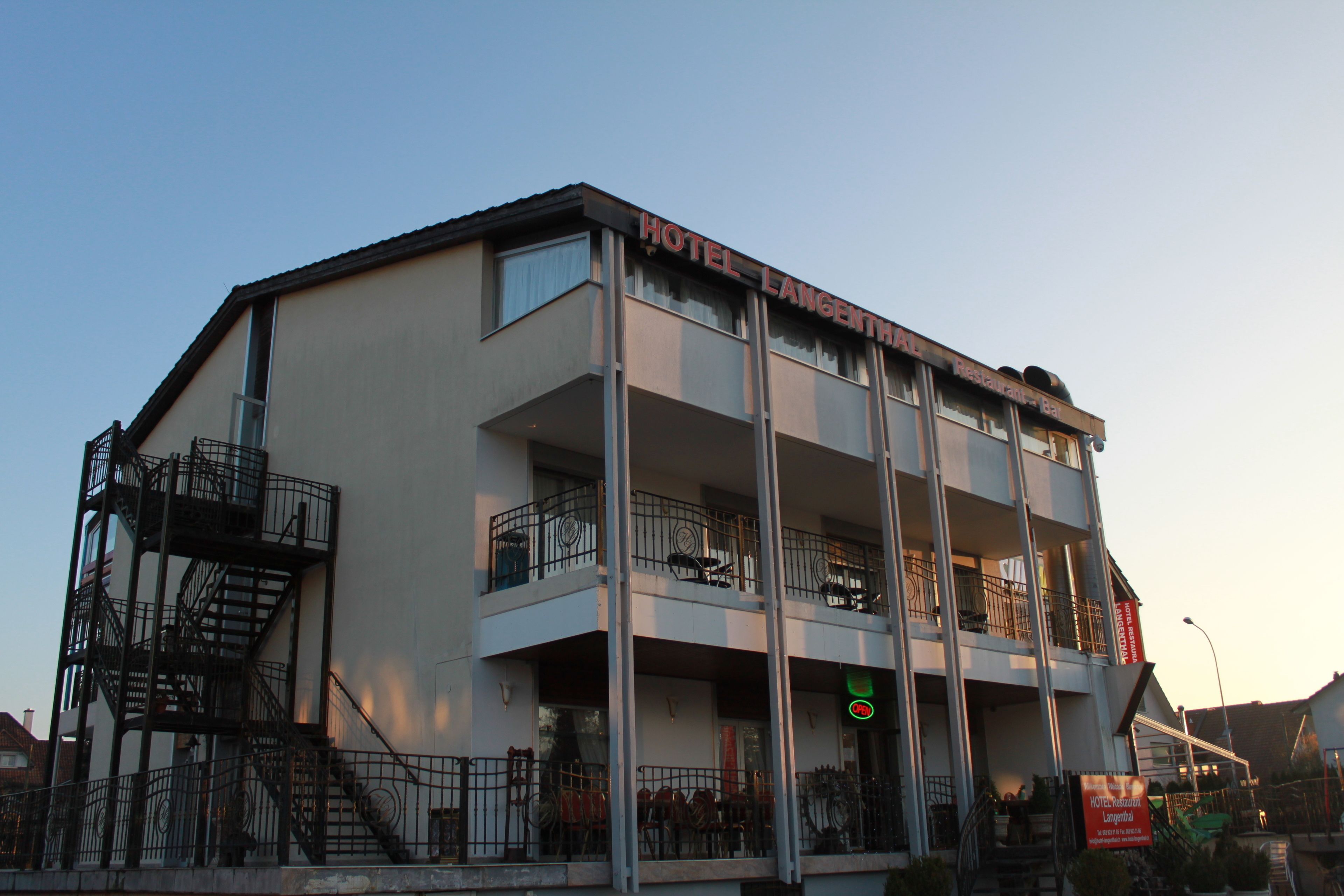 A multi-story hotel with balconies and a staircase on the left.