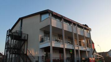 A multi-story hotel with balconies and a staircase on the left.