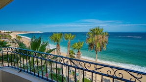 A balcony with a view of a beach and ocean. - Beachfront 4th Floor with Stunning Views to Lands End, Medano Beach and Cabo San Lucas Bay (Cabo San Lucas)