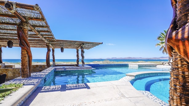 A pool area with a pergola and a view of the ocean. - BEACHFRONT, PRIVATE POOL, GOLF, Concierge, Daily Maid and Chef-Meal Services at Paraiso del Mar (La Paz)