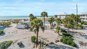 A beachfront property with a pool, palm trees, and a view of the ocean. - Stay and Play all Day in this Very Nice Spacious Beach Resort Villa! C1622A (Englewood)