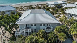 A beachfront hotel with multiple buildings, each featuring a flat roof and a balcony. The property is surrounded by palm trees and has a view of the ocean. - Stay and Play all Day in this Very Nice Spacious Beach Resort Villa! C1622A (Englewood)
