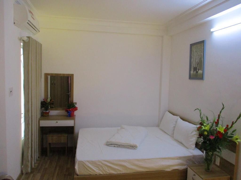 Ein Schlafzimmer mit Bett, Nachttisch, Schreibtisch, Stuhl und Spiegel.