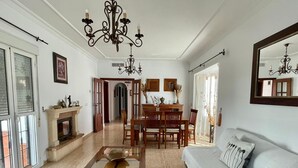 A spacious living room with a fireplace, a dining area, and a large mirror.