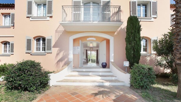 A building with a central entrance, a staircase leading up to a balcony, and a sign indicating a guest room. - Apartment in French Riviera with Pools (GRIMAUD)