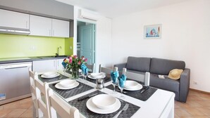 A modern kitchen with a dining area set for four. - Apartment in French Riviera with Pools (GRIMAUD)