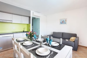 A modern kitchen with a dining area set for four. - Apartment in French Riviera with Pools (GRIMAUD)