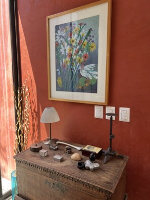 A wooden chest with decorative items, a framed painting of flowers, and wall-mounted switches. - Department in the Heart of Oaxaca (Oaxaca)