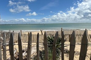 A beach with a wooden fence in the foreground and a clear sky. - Nice apartment on the island of Ile de Ré (RIVEDOUX PLAGE)