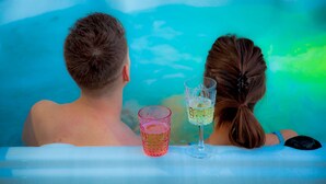 Due persone in una vasca da bagno con uno sfondo blu e verde.