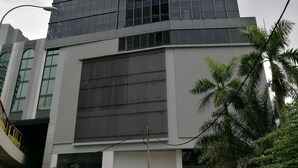 A modern building with a glass facade and a sign for the Bangsar Trade Centre.