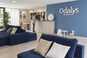 A reception area with a blue wall, a reception desk, and seating arrangements.