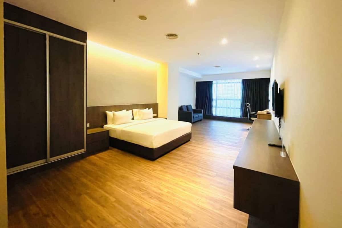 Una habitación de hotel moderna con una cama grande, un escritorio y un televisor.