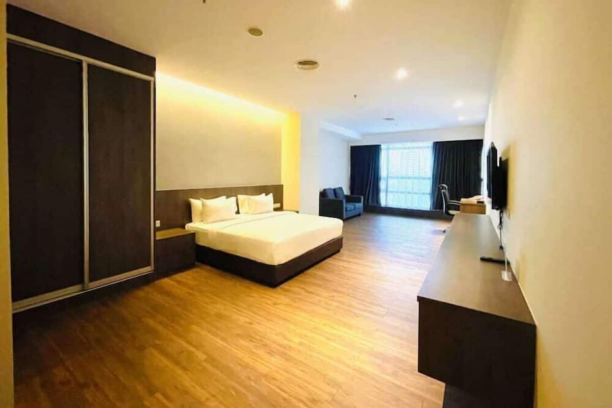 Una habitación de hotel con una cama grande, un escritorio, un armario y un televisor.