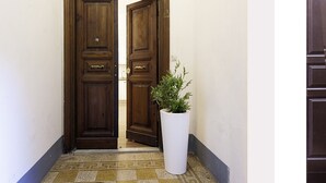 A wooden double door with a white planter in front.