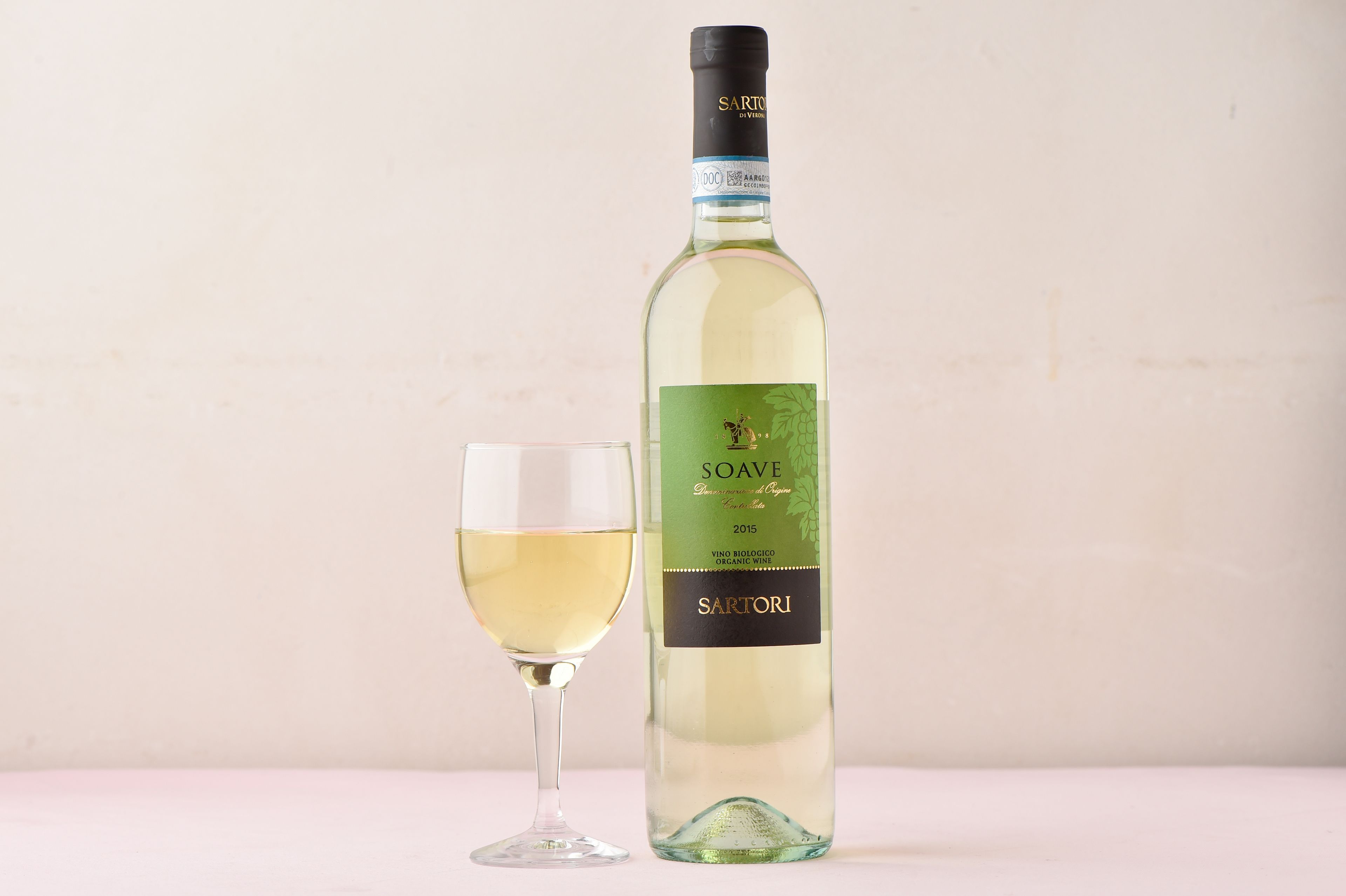 Une bouteille de vin de Soave et un verre de vin.