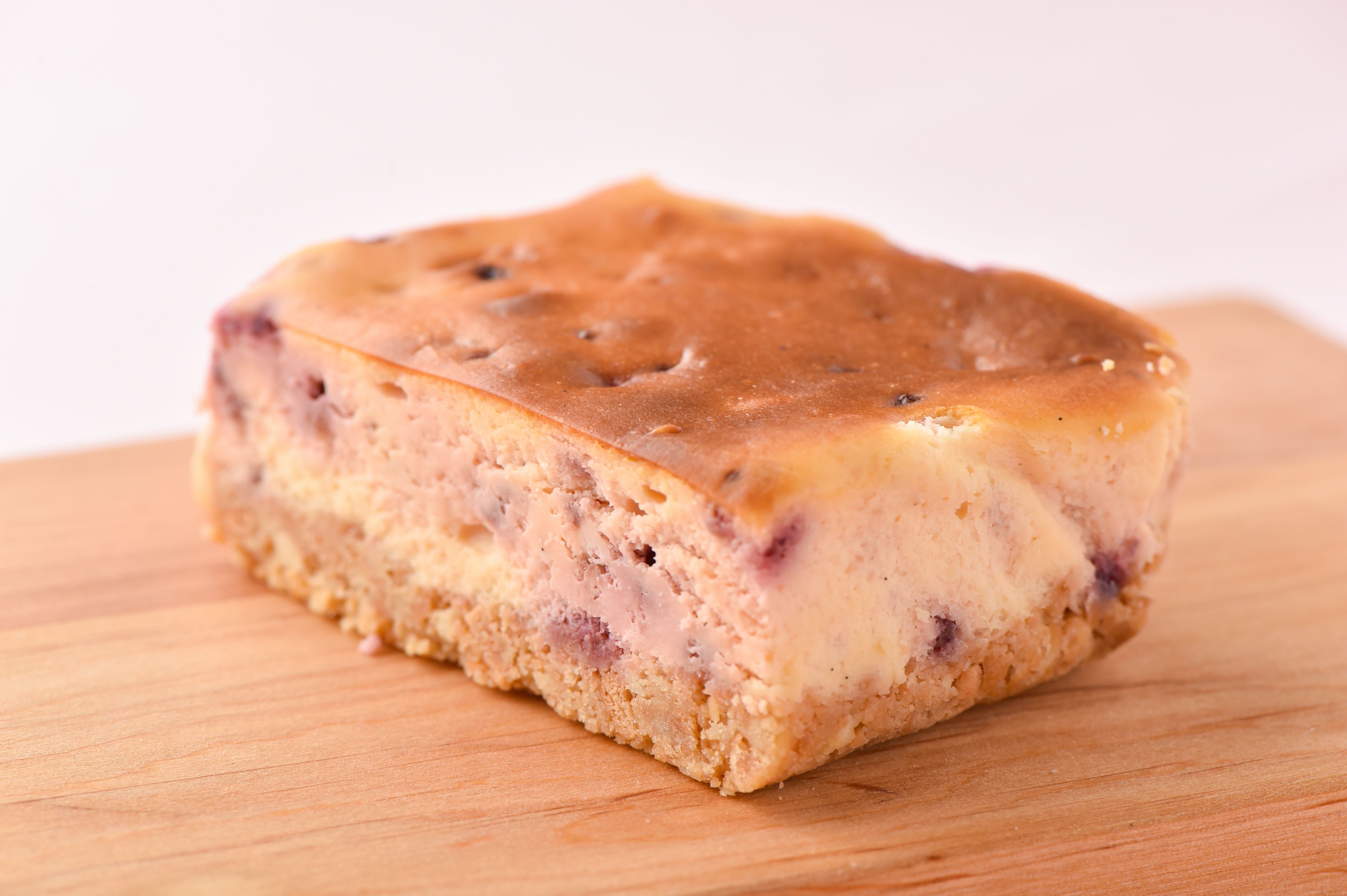 A single slice of cake on a wooden surface.